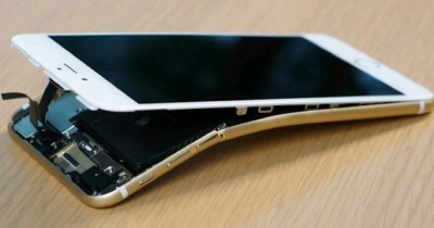 iPhone màu vàng bị cong khung, bung màn hình lộ pin và linh kiện bên trong