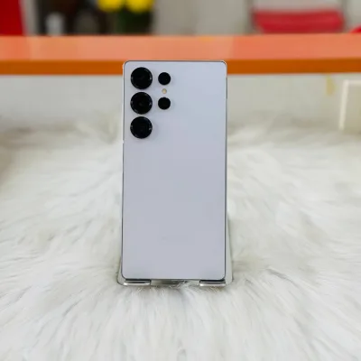 Điện thoại Samsung Galaxy S25 Ultra màu trắng bạc, mặt lưng với cụm camera nổi bật trên nền lông trắng.